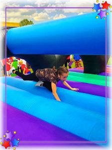 Girl crawling through an inflatable during a children's games