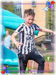 Boy running thropugh bubbles on a ssecondry school It's A Knockout event